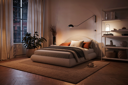 SoftFrame Designs' Luna bed frame and headboard in a bedroom with plant, lamp, and shelves around it