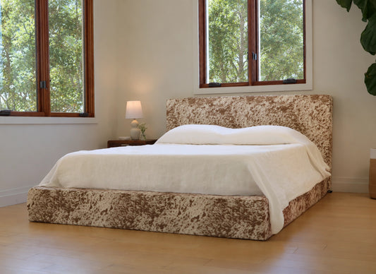 All cushioned vegan pony hide bed with tree view outside the window 