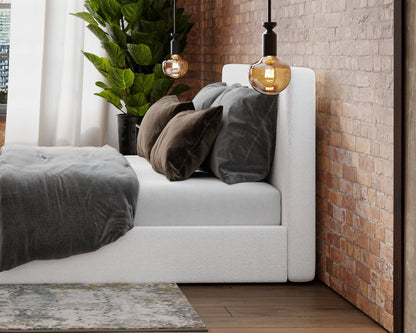 All cushioned headboard in white bouclé in a loft bedroom with warm lighting