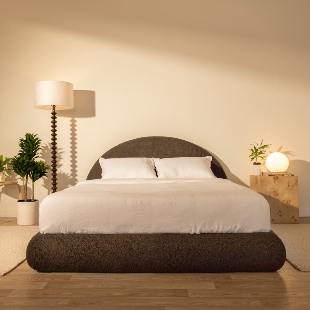 Modern bedroom with a chocolate brown bed frame, lamp, and plants in a warm setting | Luna Set in Chocolate | SoftFrame® Designs