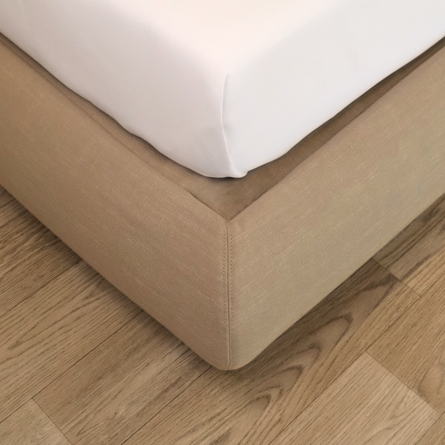 Tan bed frame corner with white mattress on a wooden floor | Luna Bed Frame | SoftFrame® Designs