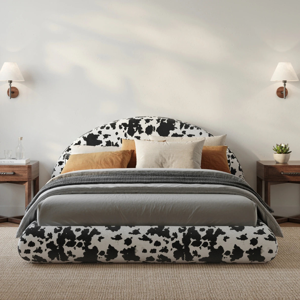 All cushioned bed with cow print headboard and gray bedding in a bedroom setting.