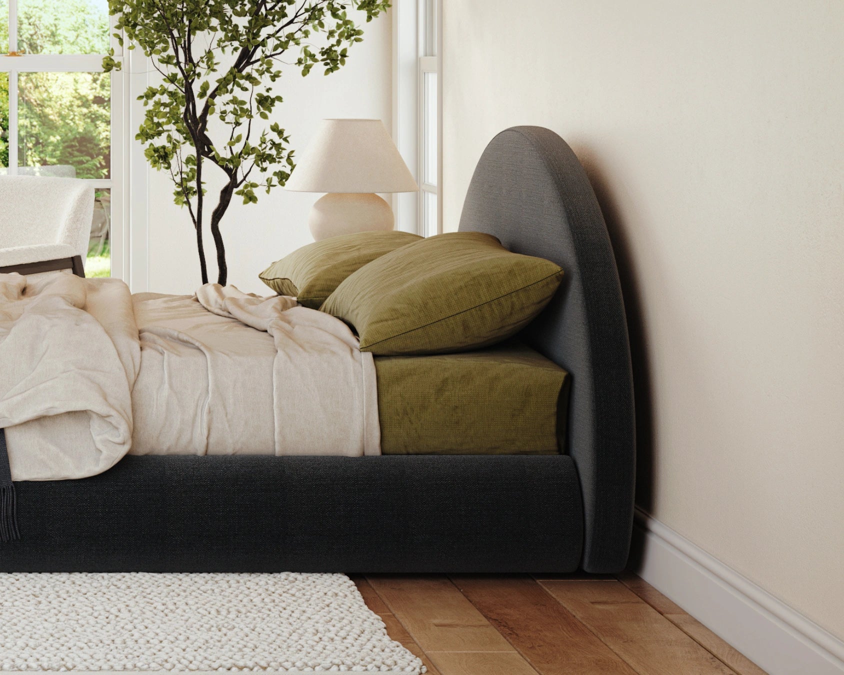 Bedroom with a bed featuring green pillows and a lamp in the corner.