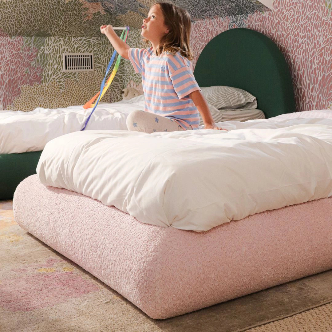 girl playing on a pink all cushioned bed frame