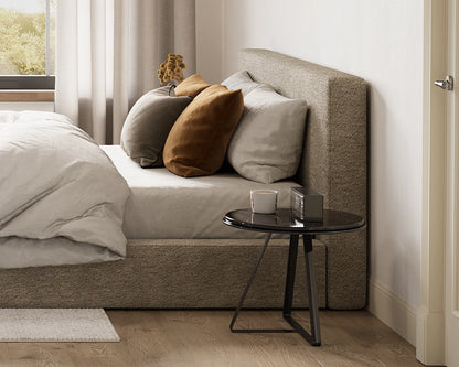 Modern bedroom with a bed, pillows, and a small table.