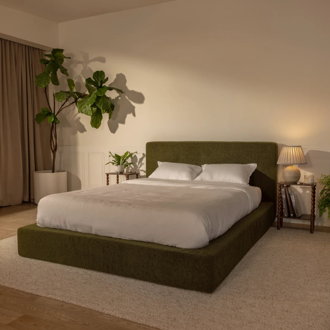Modern bedroom with a dark green bed frame, white bedding, and decorative plants | Ultra Set in Moss | SoftFrame® Designs