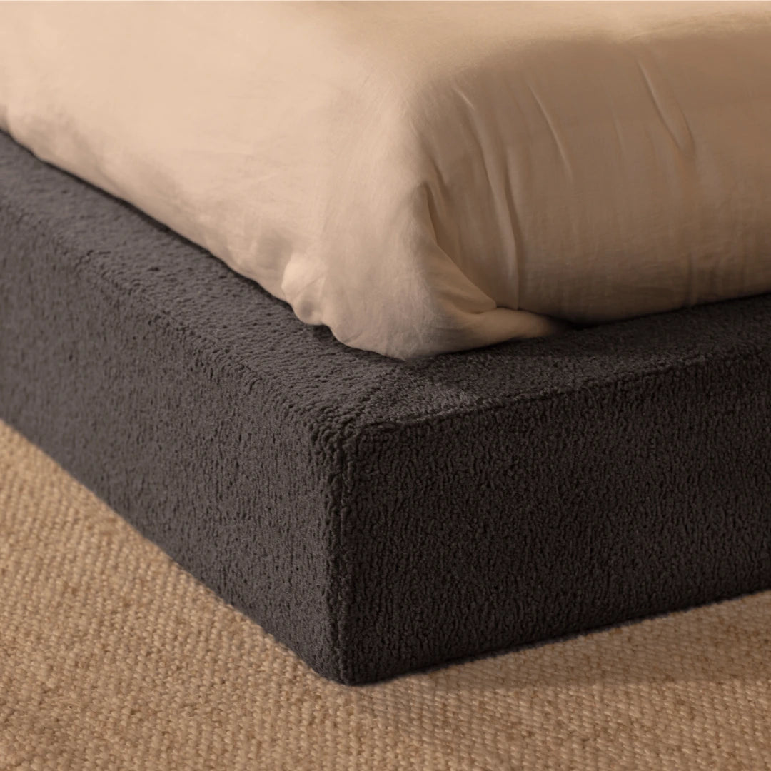 Close up corner of a soft, dark gray bed frame with mattress on top | SoftFrame® Designs