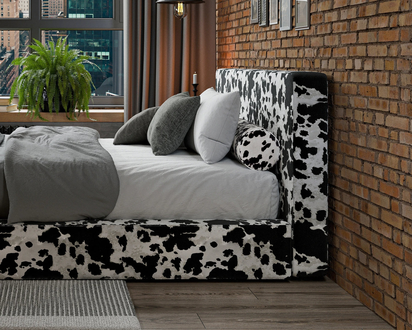 Bed with cow print headboard against a brick wall