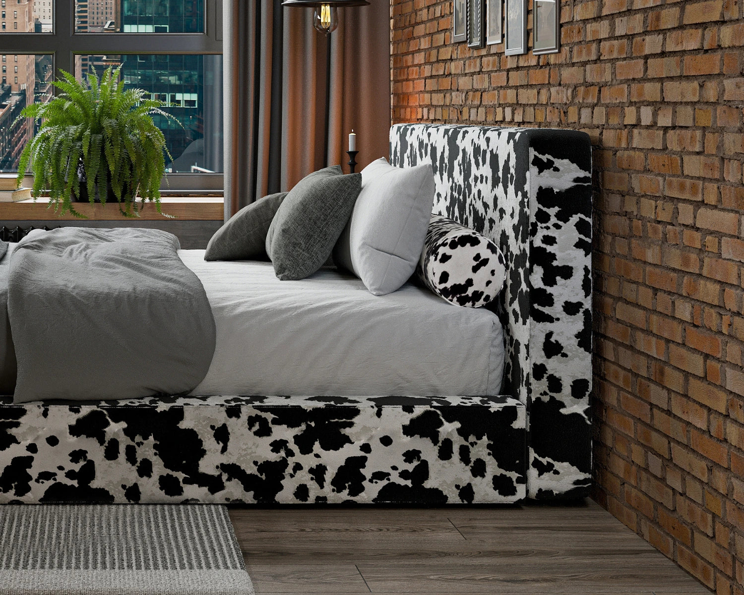 Bed with cow print headboard against a brick wall