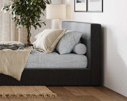Gray upholstered bed with pillows in a bedroom setting