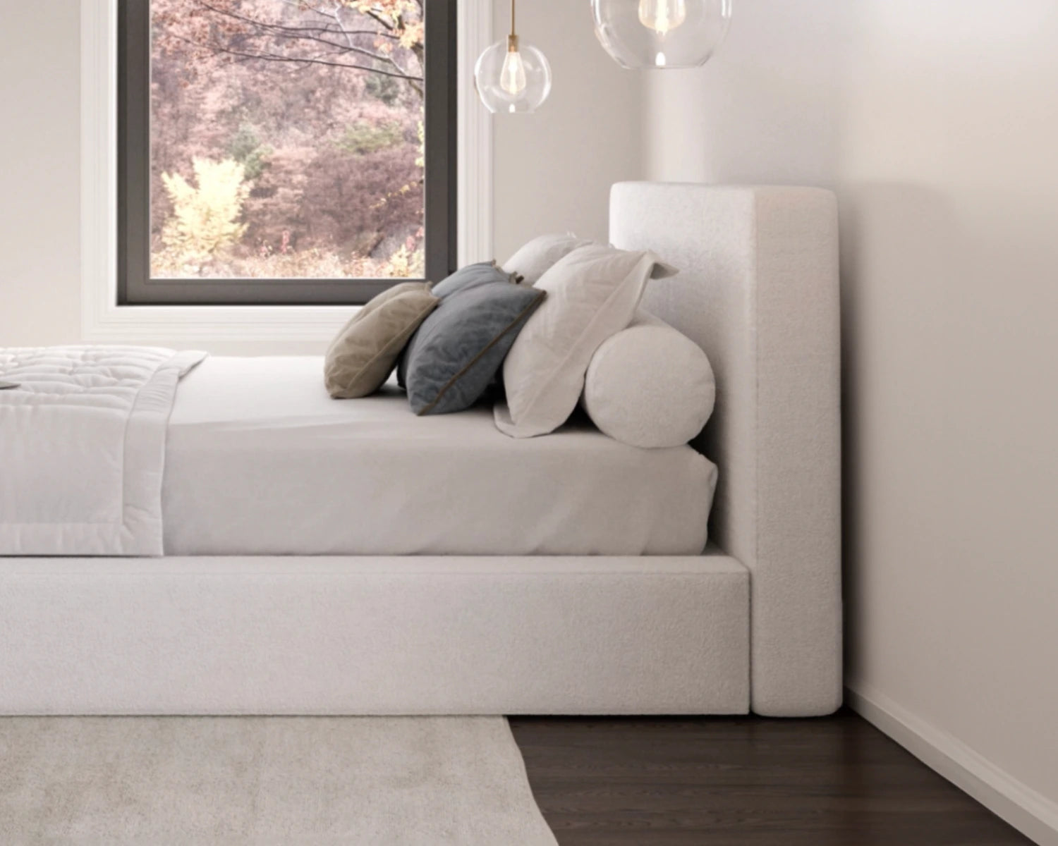 Modern bedroom with a all cushioned bed and decorative pillows near a window.