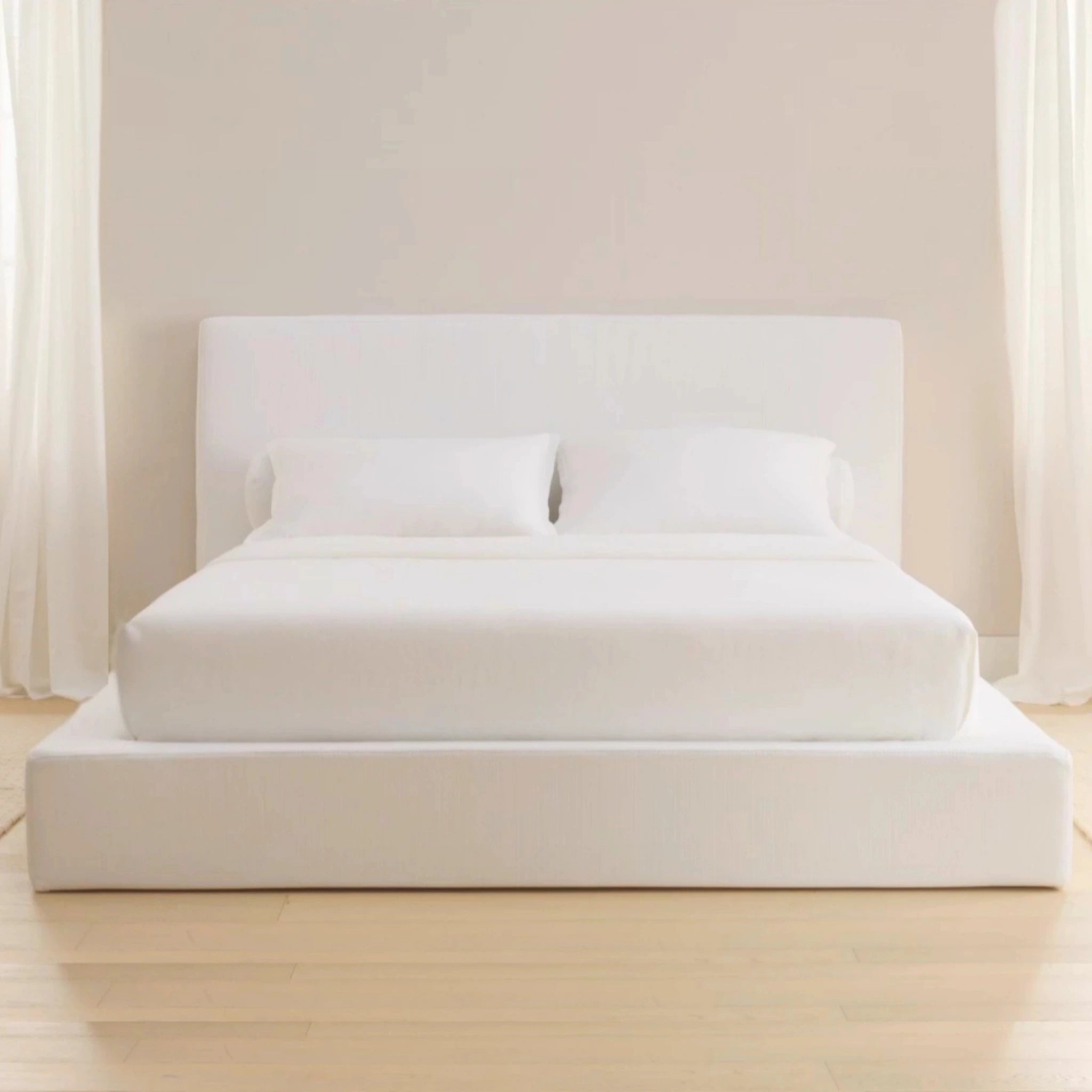 White cushioned cloud bed with white bedding in a minimalistic room | SoftFrame Designs