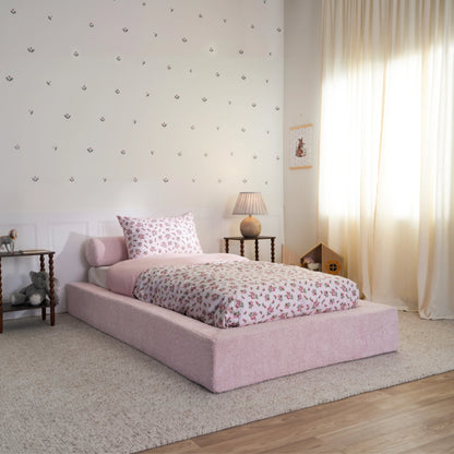 Cotton candy bed frame 3/4 view. All cushioned pink bed frame in a kids bed room with floral decal and toys.