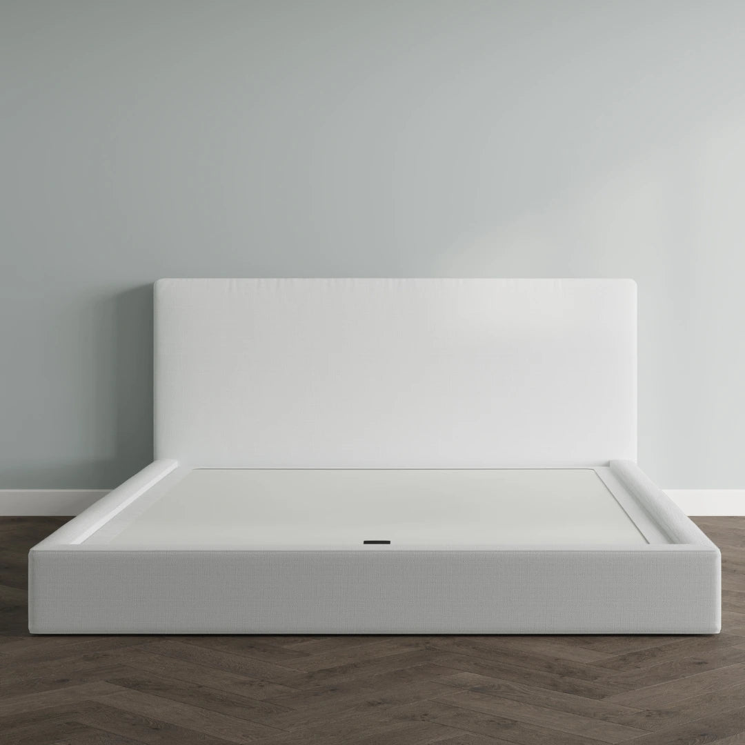 White bed frame against a gray wall