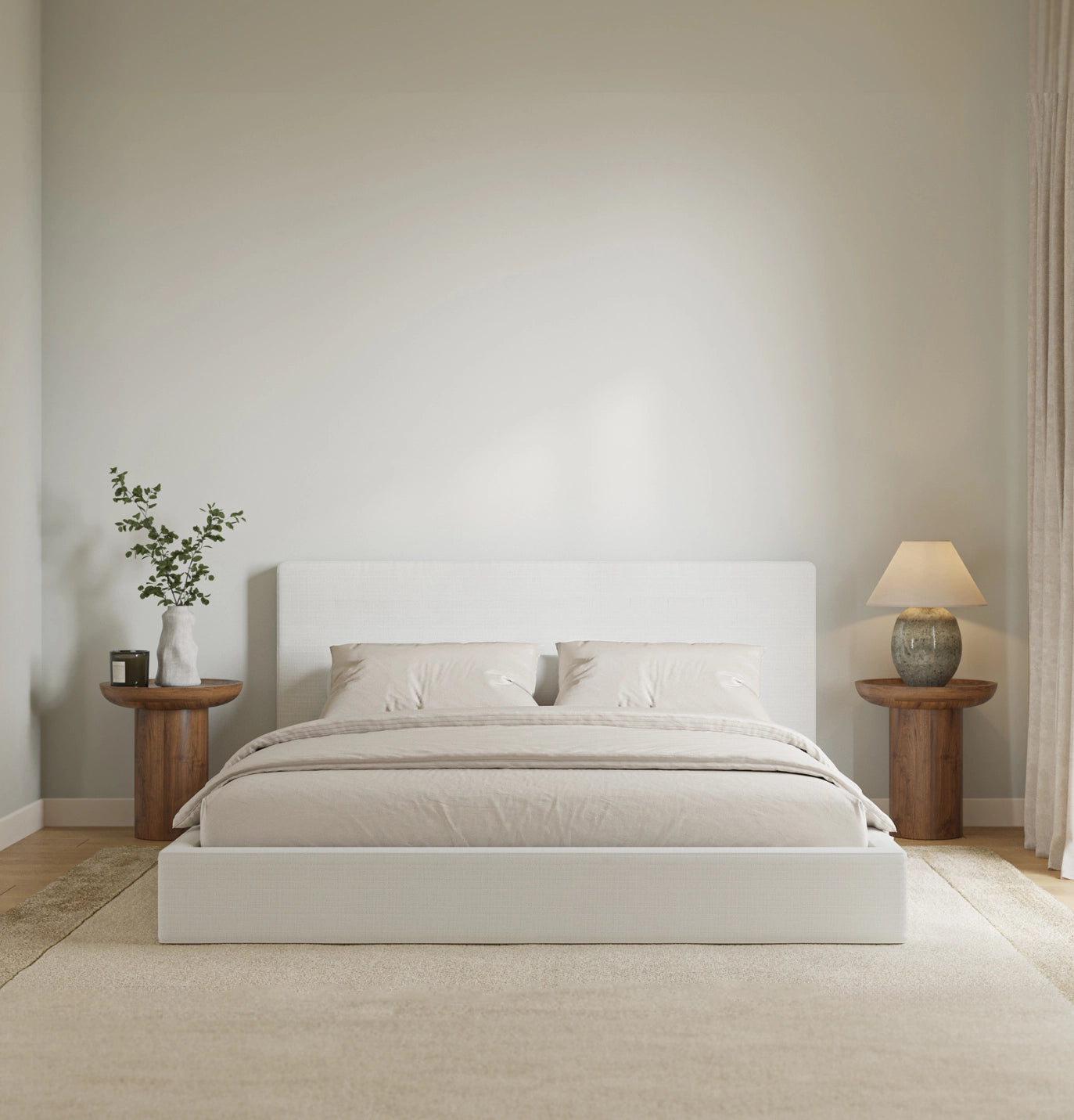 Minimalist bedroom with a white bed, wooden side tables, and a lamp.