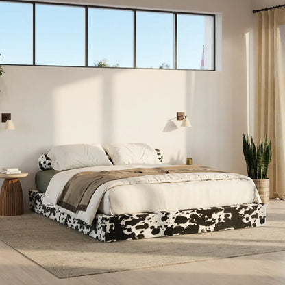 Modern bedroom with a bed featuring a cow print bed frame, white bedding, and decorative pillows | Classic Bed Frame in Vegan Cowhide | SoftFrame Designs