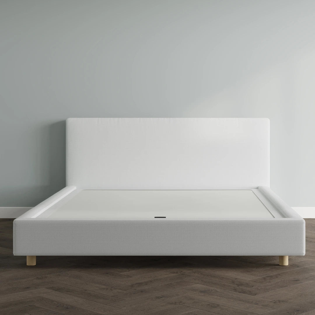 White bed frame against a gray wall