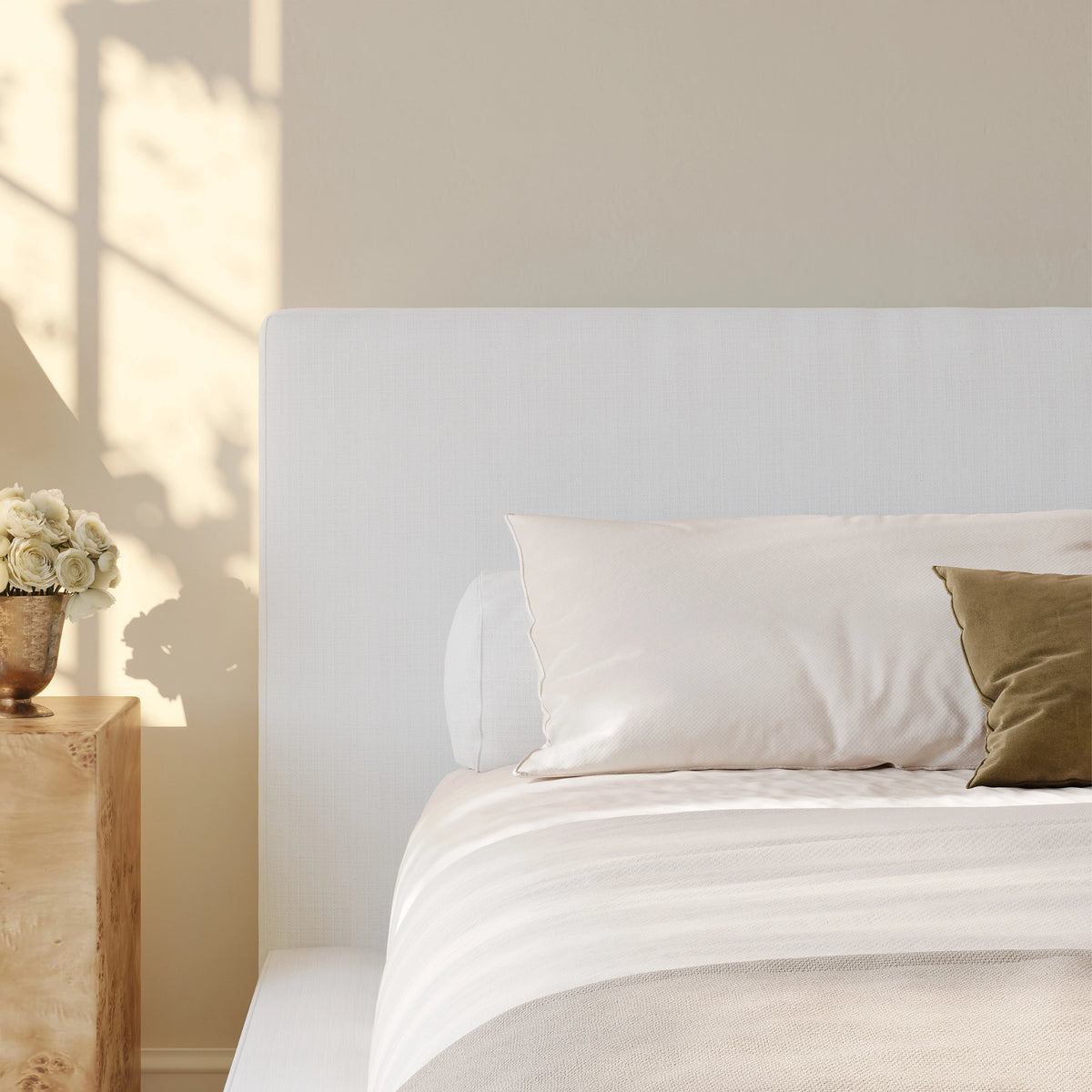 Close up of the white headboard in a warm neat minimalist room