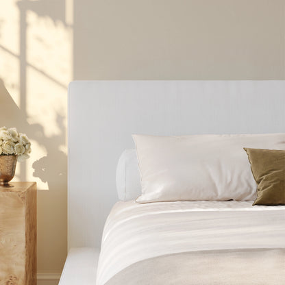 Close up of the white headboard in a warm neat minimalist room