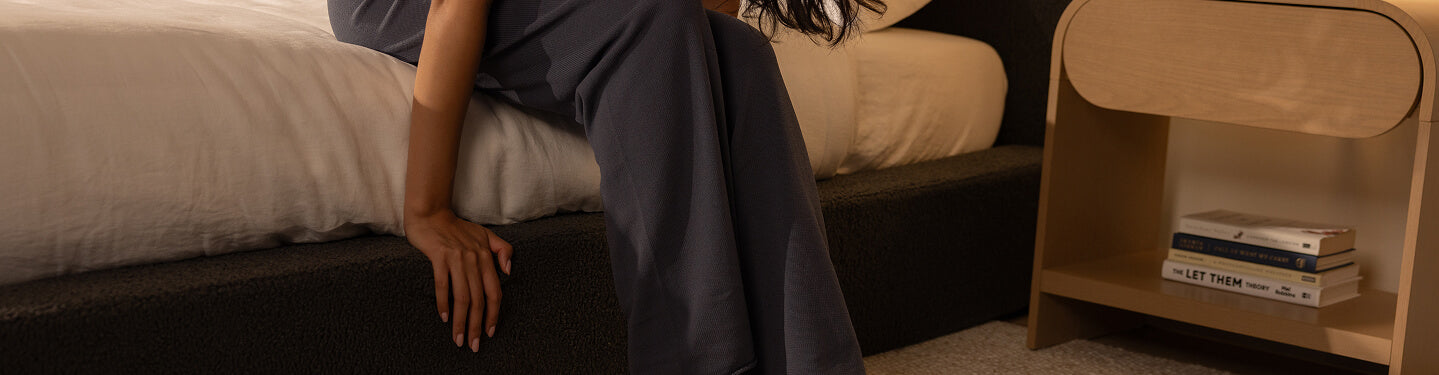 Person sitting on a SoftFrame bed with a nightstand in the background