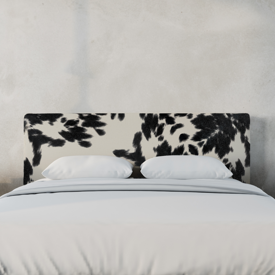 An upholstered headboard with a black and white vegan cowhide pattern | Classic Headboard in Vegan Cowhide | SoftFrame Designs