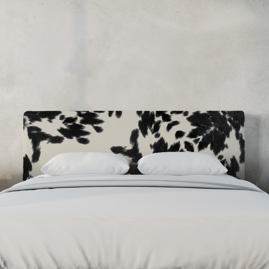 An upholstered headboard with a black and white vegan cowhide pattern | Classic Headboard in Vegan Cowhide | SoftFrame Designs
