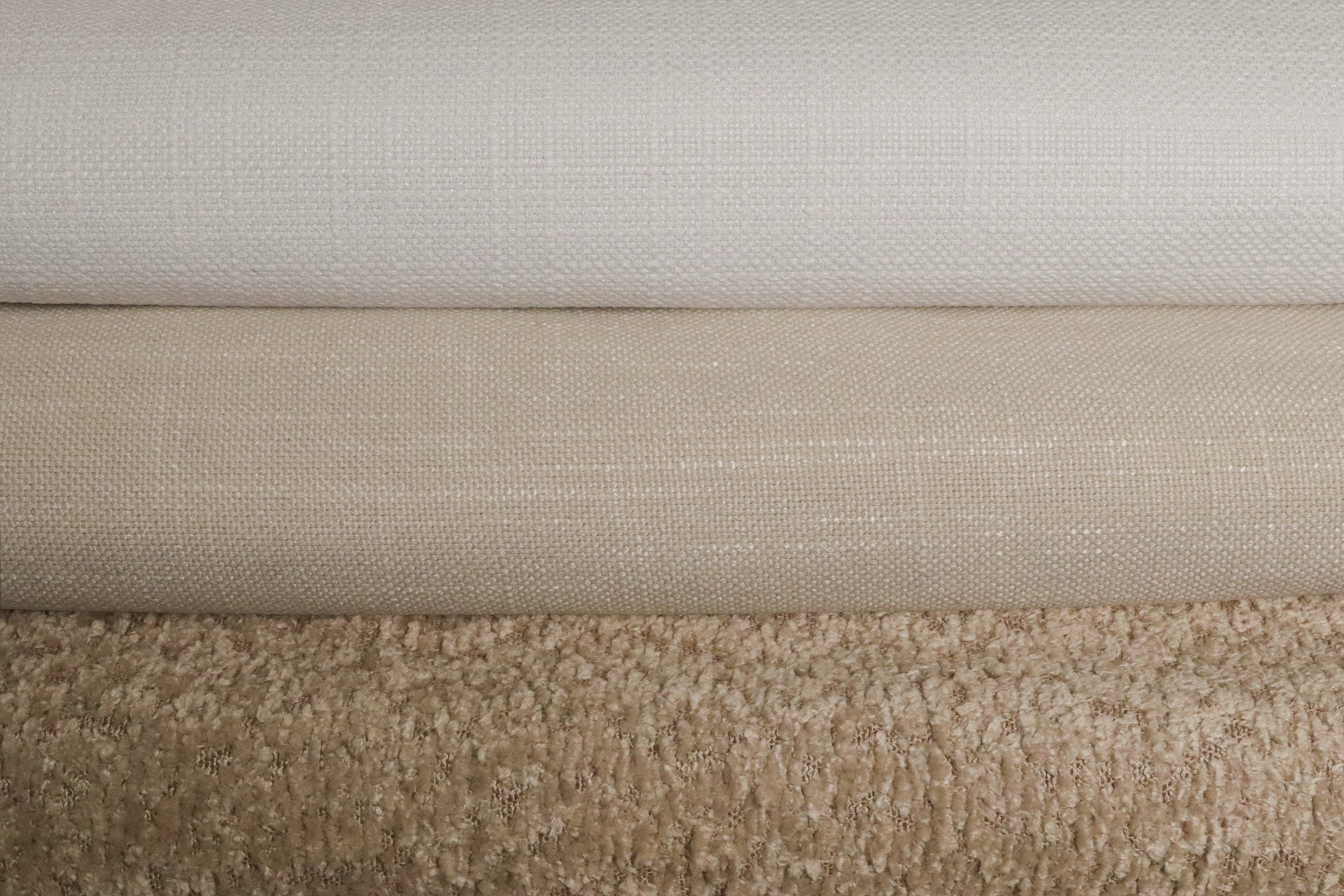 Three swatches of fabric in white, beige, and boucle light brown