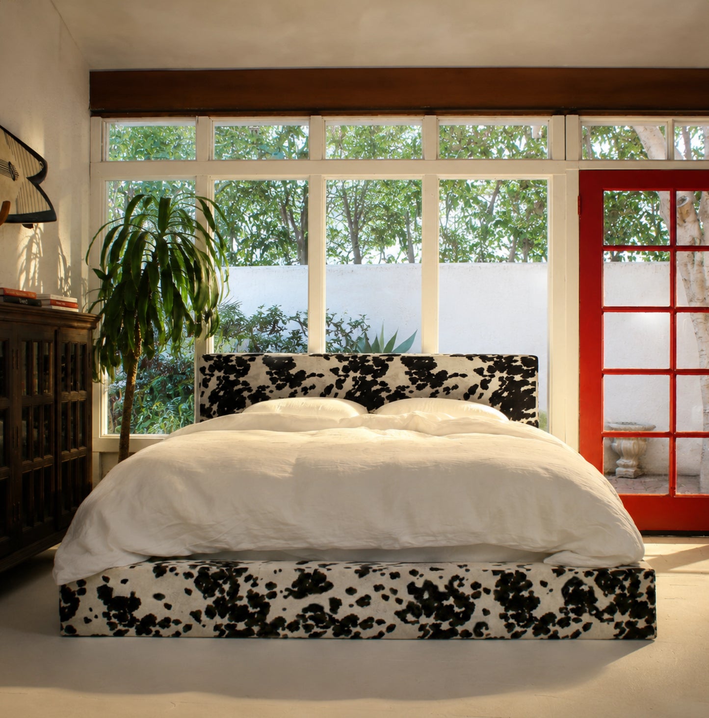 Vegan cowhide bed in a bedroom with windows