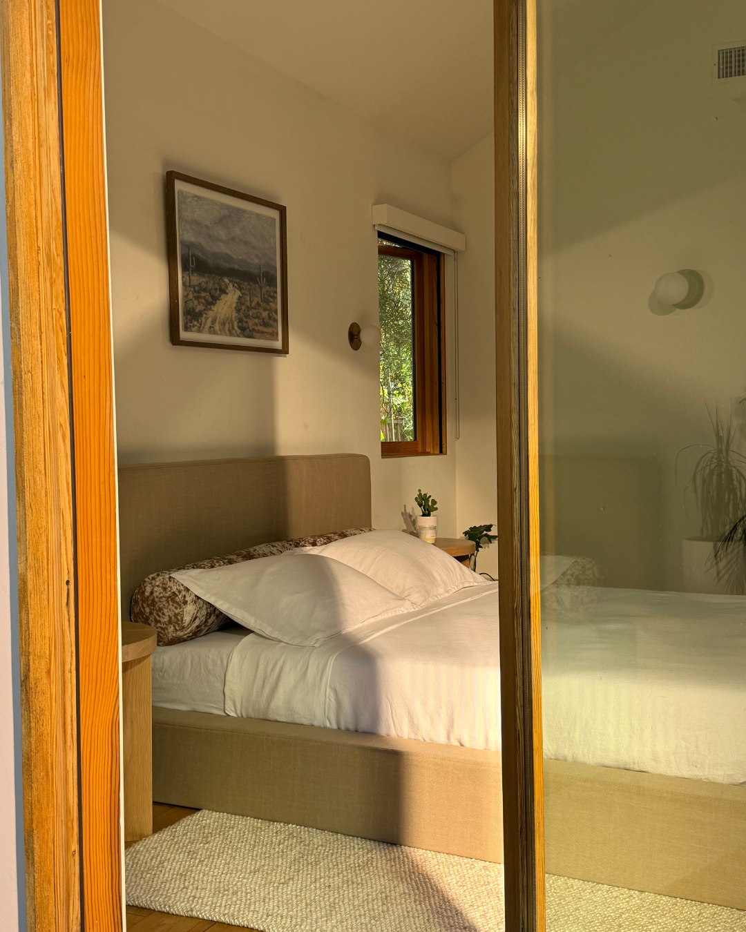 side view of a bed frame in a warm beige in an organic bedroom setting