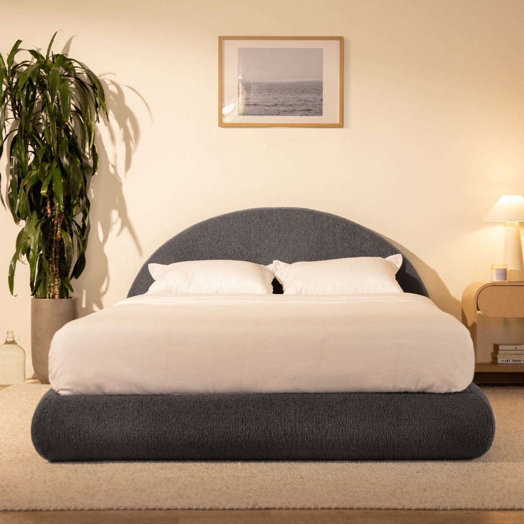 Bedroom with a charcoal grey, curved bed frame and headboard, nightstand, and framed picture on the wall | Luna Set in Storm | SoftFrame® Designs