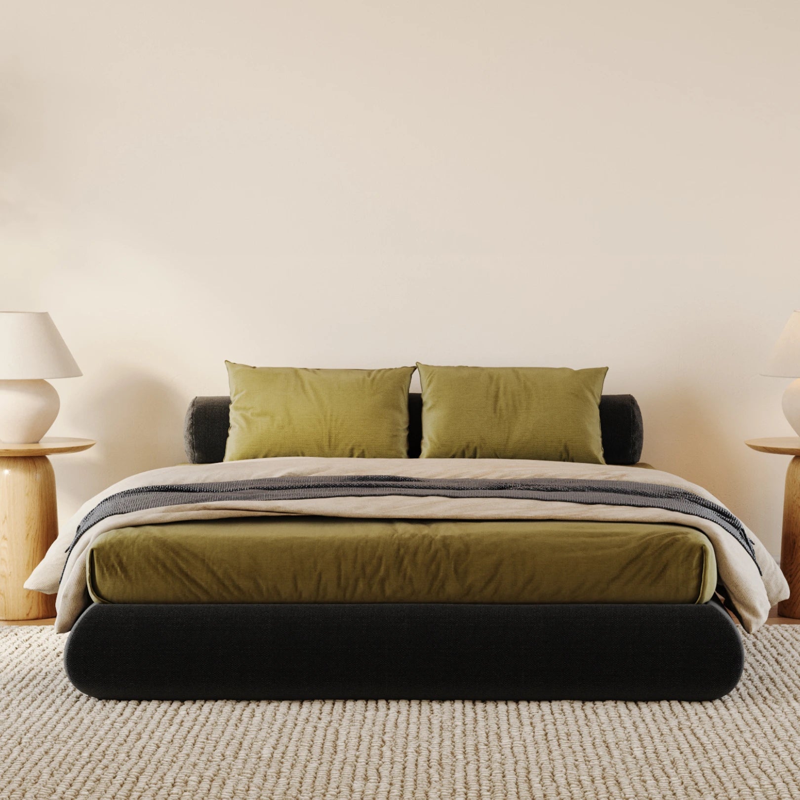 All cushioned black bed frame with green sheets in a minimalistic bedroom