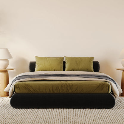 All cushioned black bed frame with green sheets in a minimalistic bedroom