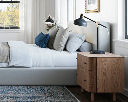 Modern bedroom with a bed, nightstands, and decorative pillows.