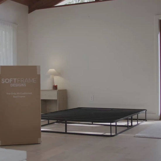 A woman setting up a Luna all cushioned bed set in the color Dune.