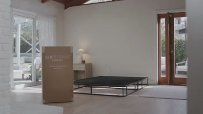 A woman setting up a Luna all cushioned bed set in the color Dune.
