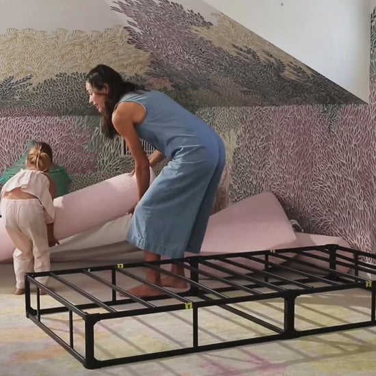 A softframe designs all cushioned bed frame and headboard set in the style Luna in the fabric color cotton candy, in a childs room with colorful wallpaper