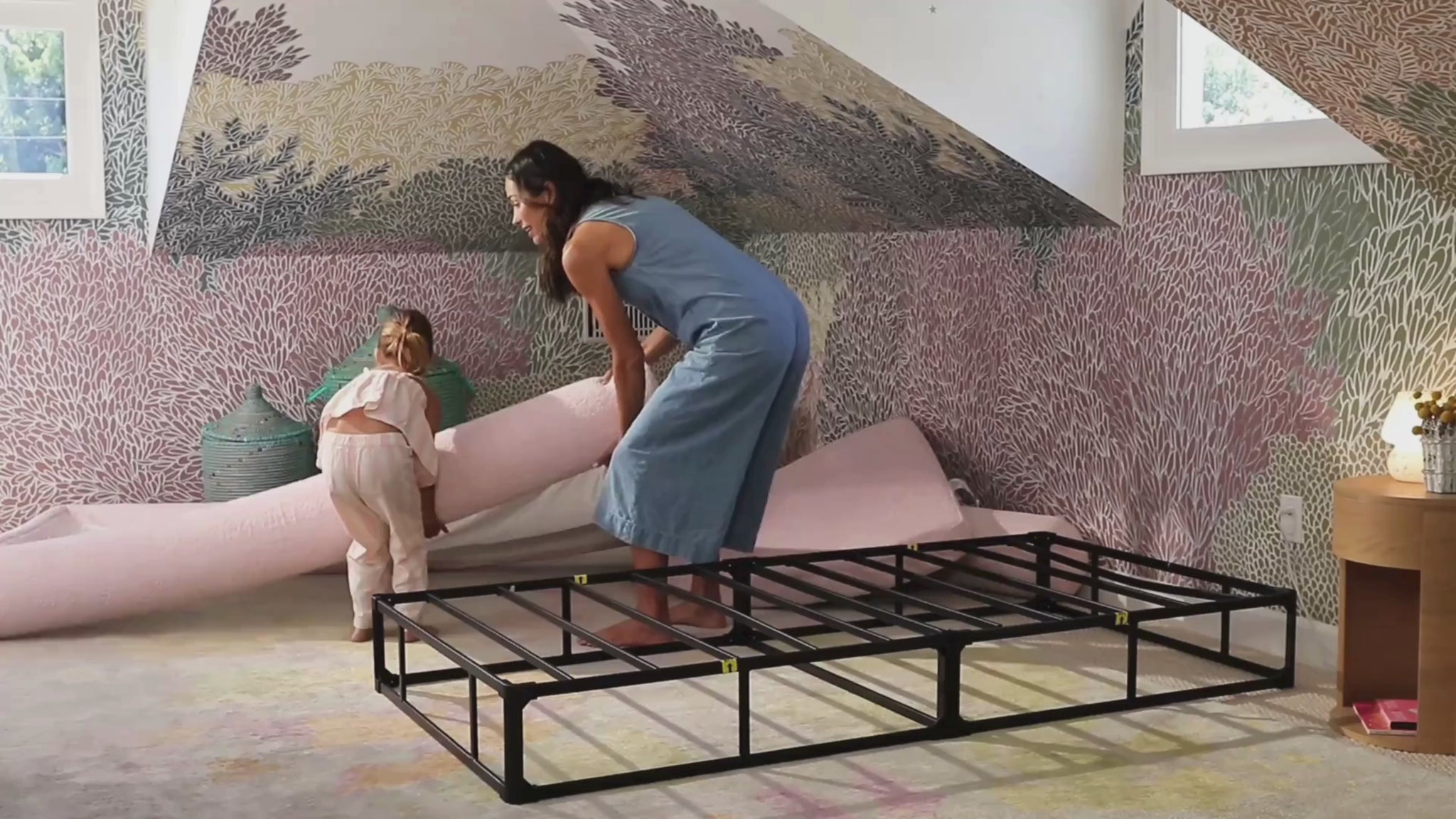 A softframe designs all cushioned bed frame and headboard set in the style Luna in the fabric color cotton candy, in a childs room with colorful wallpaper