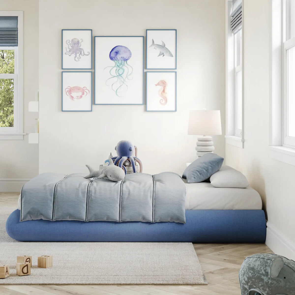 A side view of a kids all cushioned bed frame in sky in a gray kids bed room with big windows with trees. 