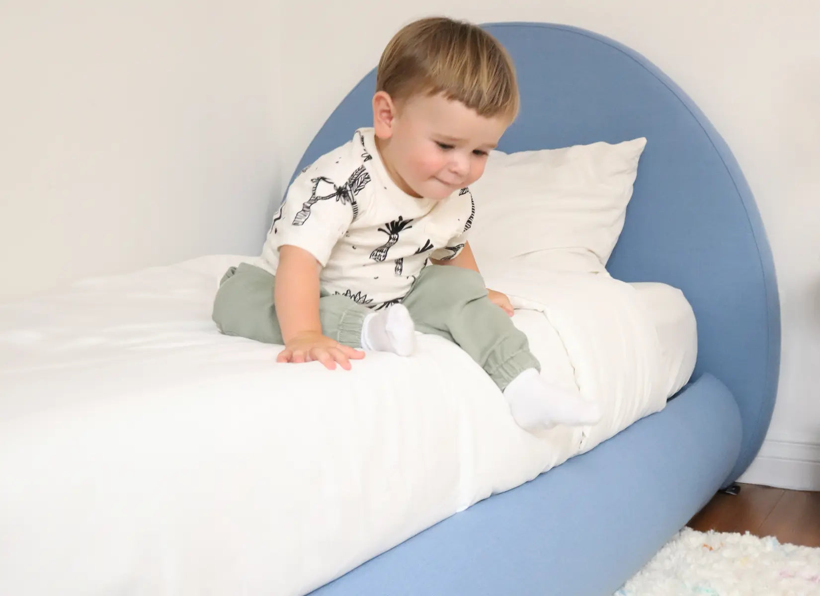 Child playing on a blue all cushioned bed