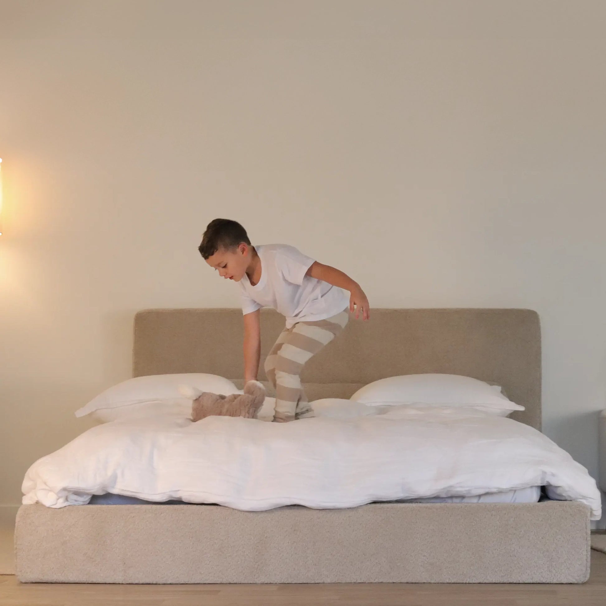 Child playing on a bed in a bedroom