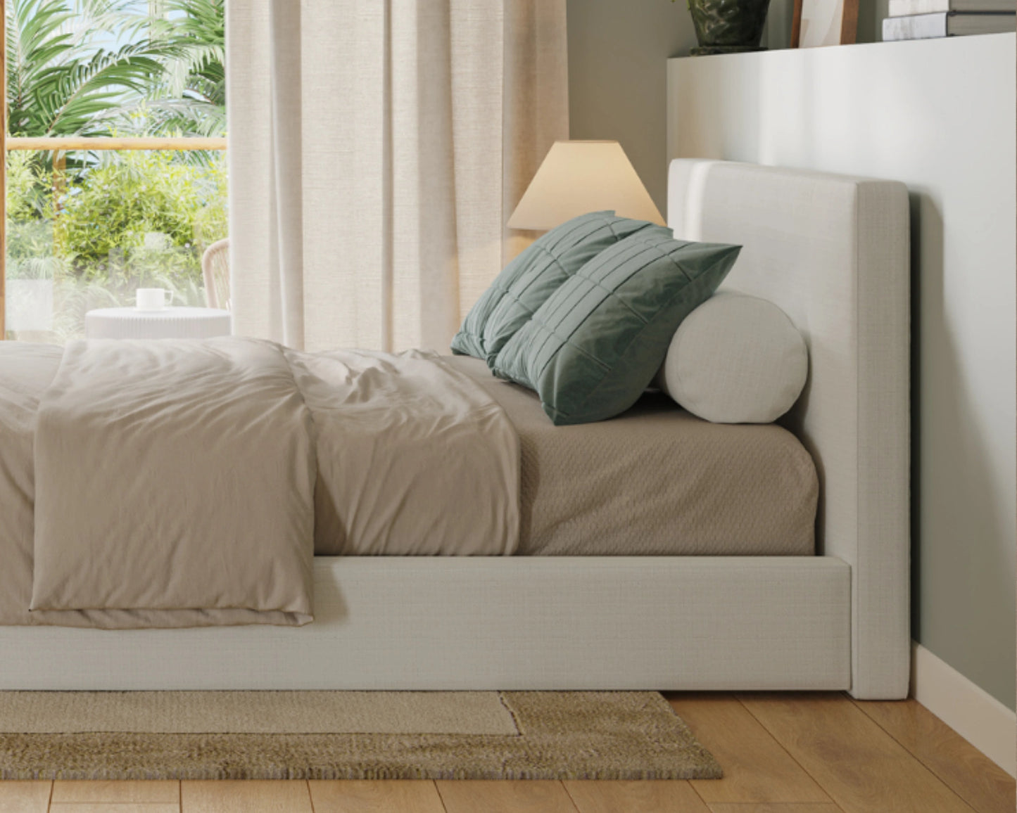 Neatly made bed with beige bedding and green pillows in a bright bedroom.