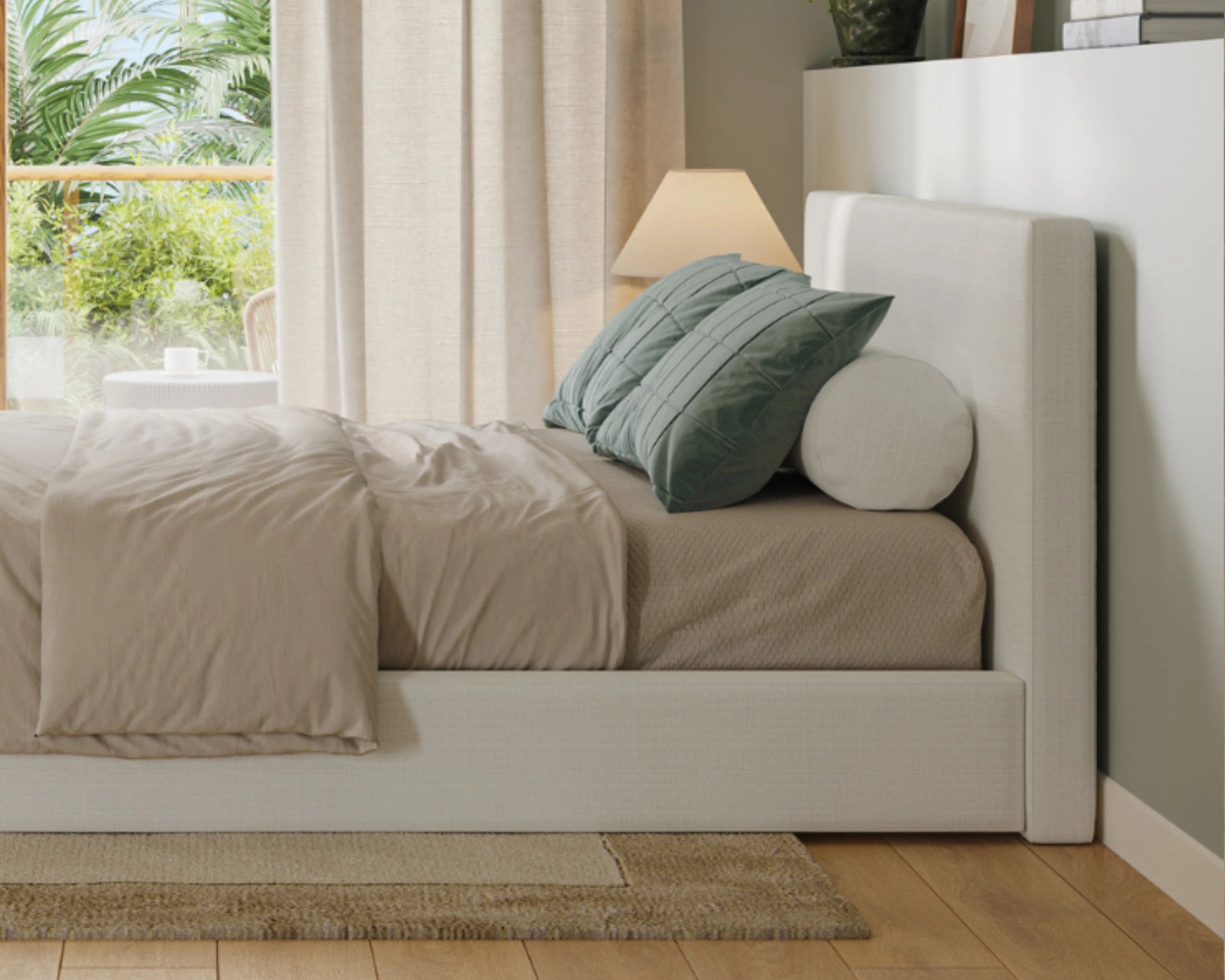 Neatly made bed with beige bedding and green pillows in a bright bedroom.